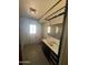Bathroom with damaged flooring, plain white walls, a sink, mirror and walk in shower at 9754 E Sunland Ave, Mesa, AZ 85208