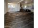 A large living room featuring damaged flooring and white walls at 9754 E Sunland Ave, Mesa, AZ 85208