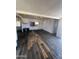 A living room featuring damaged flooring, blank white walls, and a ceiling fan at 9754 E Sunland Ave, Mesa, AZ 85208