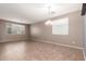 Bright, open living room with large window, chandelier, and tile flooring at 10351 W Carlota Ln, Peoria, AZ 85383