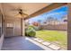 Covered patio with a view of the lush backyard, including beautiful flower bushes and green grass at 10517 W La Reata Ave, Avondale, AZ 85392