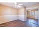 Cozy bedroom featuring a ceiling fan, wood-look flooring, and mirrored closet doors at 10517 W La Reata Ave, Avondale, AZ 85392