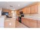 Bright kitchen featuring tile countertops, oak cabinetry, and modern black appliances at 10517 W La Reata Ave, Avondale, AZ 85392