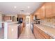 Well-lit kitchen featuring tile countertops and backsplash, oak cabinetry and black appliances at 10517 W La Reata Ave, Avondale, AZ 85392