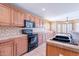 Well-equipped kitchen with tile countertops, oak cabinets, and modern appliances at 10517 W La Reata Ave, Avondale, AZ 85392