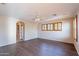 Bright living room featuring wood-look floors, neutral walls, and natural light from shuttered windows at 10517 W La Reata Ave, Avondale, AZ 85392