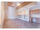 Open living room with custom built-ins, ceiling fan and tile flooring at 10517 W La Reata Ave, Avondale, AZ 85392