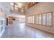Bright, open living room featuring high ceilings, tile flooring, and large windows with plantation shutters at 10517 W La Reata Ave, Avondale, AZ 85392