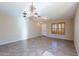 Bright living room with tiled floors, a decorative chandelier, and natural light at 10517 W La Reata Ave, Avondale, AZ 85392