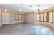 Inviting living room featuring tiled flooring, natural light, and a charming chandelier at 10517 W La Reata Ave, Avondale, AZ 85392