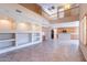 Spacious living room with custom built-ins, tile floors, and abundant natural light at 10517 W La Reata Ave, Avondale, AZ 85392