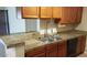 Updated kitchen with wooden cabinets, granite countertops, and stainless steel sink at 10610 S 48Th St # 1074, Phoenix, AZ 85044