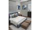 Beautifully staged bedroom with decorative pillows, a large picture window, and two upholstered ottomans at 112 W Vogel Ave, Phoenix, AZ 85021