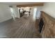Spacious living room with an open floor plan features a modern kitchen, brick fireplace, and wood floors at 112 W Vogel Ave, Phoenix, AZ 85021