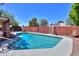 Backyard swimming pool surrounded by concrete patio, palm tree, and enclosed by a brick fence at 1220 E Avenida Ellena St, Casa Grande, AZ 85122