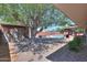 Backyard with mature shade tree, detached shed, gravel landscaping, with pool and covered patio in background at 1220 E Avenida Ellena St, Casa Grande, AZ 85122