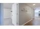 Hallway with closet and towel rack, adjacent to the kitchen with white cabinets at 1220 E Avenida Ellena St, Casa Grande, AZ 85122