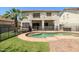 Beautiful backyard with green lawn, swimming pool, tropical tree, and patio at 12209 W Washington St, Avondale, AZ 85323