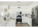 Bright, white kitchen features stainless steel appliances, modern finishes and an island with quartz countertop at 12209 W Washington St, Avondale, AZ 85323