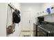 Functional laundry room equipped with modern washer and dryer, hanging rack, and ample storage solutions for convenience at 12209 W Washington St, Avondale, AZ 85323