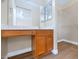 A vanity in the bathroom has wood cabinets, a mirror, and a view of the nearby closet at 12450 W Hearn Rd, El Mirage, AZ 85335