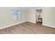 A bedroom has wood floors, neutral walls, and a window with a view of the outside at 12450 W Hearn Rd, El Mirage, AZ 85335