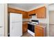 Bright kitchen featuring wood cabinets, white appliances, and laminate countertops at 12450 W Hearn Rd, El Mirage, AZ 85335