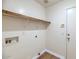 This laundry room has overhead shelving and washer/dryer hookups at 12450 W Hearn Rd, El Mirage, AZ 85335