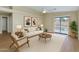 Bright living room featuring a ceiling fan, light-colored sofa, and a large sliding door at 12450 W Hearn Rd, El Mirage, AZ 85335
