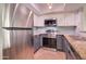Updated kitchen features stainless steel appliances, stone countertops, and modern gray cabinets at 1331 W Baseline Rd # 120, Mesa, AZ 85202