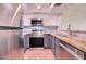 Renovated kitchen features stainless steel appliances, stone countertops, and gray and white cabinetry at 1331 W Baseline Rd # 120, Mesa, AZ 85202