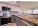 Updated kitchen boasts stone countertops, stainless appliances, and stylish gray cabinetry at 1331 W Baseline Rd # 120, Mesa, AZ 85202
