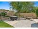 Picturesque backyard features a cozy seating area, lush lawn, and manicured planters under a large tree at 15037 N 114Th Way, Scottsdale, AZ 85255