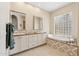 Bright bathroom featuring double sinks, soaking tub with decorative surround, and glass block window at 15037 N 114Th Way, Scottsdale, AZ 85255