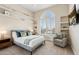 Cozy bedroom with large window, plantation shutters, built-in shelving and seating area at 15037 N 114Th Way, Scottsdale, AZ 85255