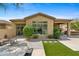 Rear exterior view featuring a covered patio, lush green plants, and manicured lawn at 15037 N 114Th Way, Scottsdale, AZ 85255