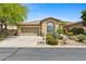 Charming home featuring a tan exterior, desert landscaping, and an attached two-car garage at 15037 N 114Th Way, Scottsdale, AZ 85255