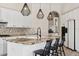 Kitchen island with granite countertops, a sink, three barstools, and pendant lighting above at 15037 N 114Th Way, Scottsdale, AZ 85255