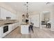 Open kitchen with granite countertops, an island with seating, white cabinetry and stainless steel appliances at 15037 N 114Th Way, Scottsdale, AZ 85255