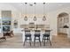 Kitchen island with stone countertops, a sink, seating for three, and pendant lighting above at 15037 N 114Th Way, Scottsdale, AZ 85255