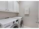 Convenient laundry room with updated washer and dryer, storage cabinets, and clean design at 15037 N 114Th Way, Scottsdale, AZ 85255