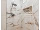 Elegant shower with marble-look tile, rainfall shower head, and built-in niche for toiletries at 15037 N 114Th Way, Scottsdale, AZ 85255