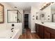 Well-lit main bathroom featuring a dual sink vanity, a soaking tub and a glass-enclosed shower at 1617 W Pecan Rd, Phoenix, AZ 85041
