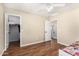 Bedroom with wood floors, ceiling fan, and doorways to a closet and hallway at 1617 W Pecan Rd, Phoenix, AZ 85041