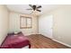 Cozy bedroom featuring a ceiling fan, wood floors, and a window with wooden shutters at 1617 W Pecan Rd, Phoenix, AZ 85041