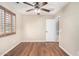 This bedroom is complete with wood floors, a ceiling fan, and a large window with plantation shutters at 1617 W Pecan Rd, Phoenix, AZ 85041