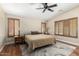 This main bedroom features wood floors, plantation shutters, a ceiling fan and neutral paint at 1617 W Pecan Rd, Phoenix, AZ 85041
