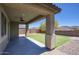 Covered back patio with ceiling fan overlooking fenced in backyard and mountain views at 16551 W Desert Ln, Goodyear, AZ 85338