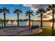 Scenic community lake view featuring palm trees, fountains and nearby seating area at 16551 W Desert Ln, Goodyear, AZ 85338