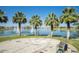 Scenic community lake view featuring palm trees, fountains and nearby seating area at 16551 W Desert Ln, Goodyear, AZ 85338